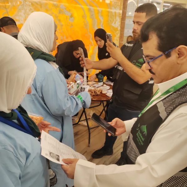 موظفون يمسحون بطاقات الحجاج بالجوال