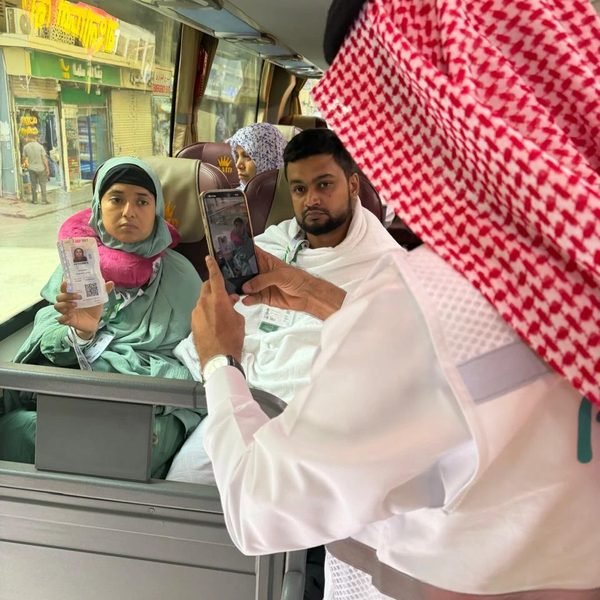 موظف يتحقق من بطاقة حاجّة داخل الحافلة