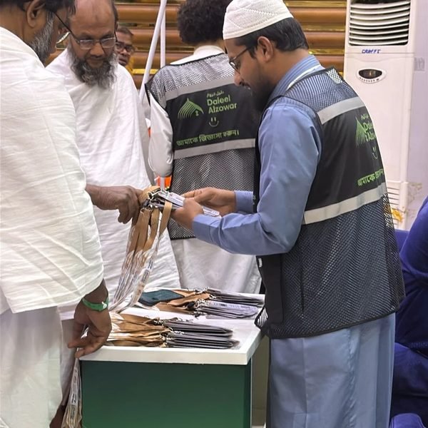 موظف يجهّز بطاقات الحجاج وعلاقاتها