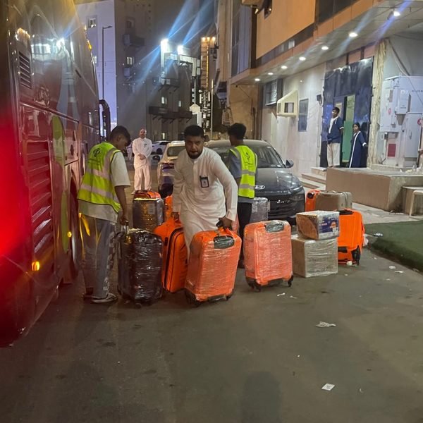 الفريق ينقل أمتعة الحجاج عند الحافلة ليلاً
