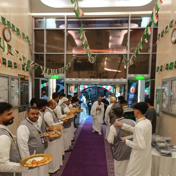 صف من الفريق يستقبل الحجاج بالضيافة عند مدخل السكن